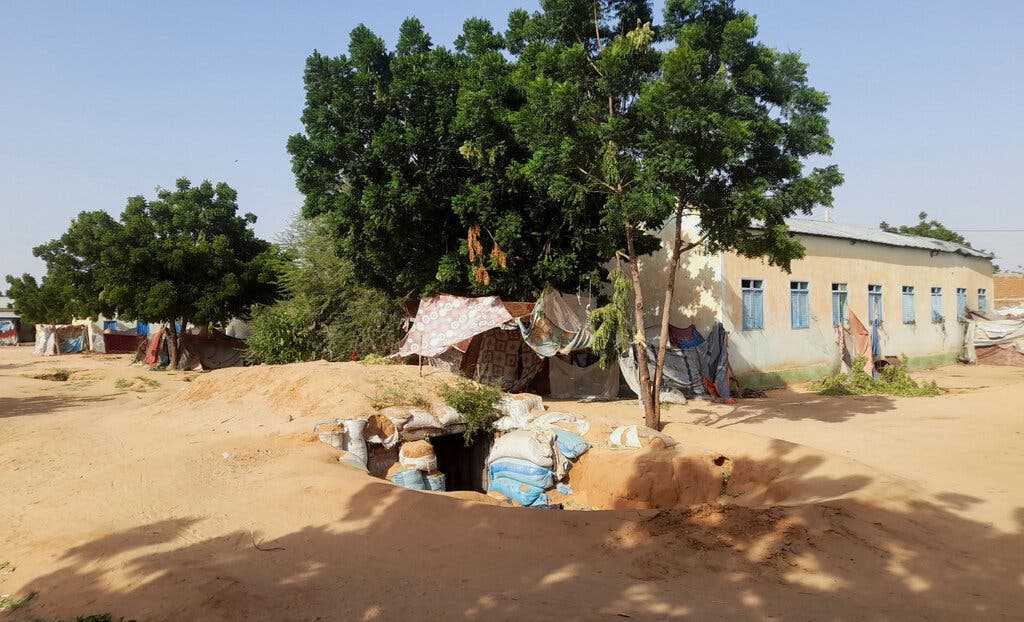 Sandbags line an underground shelter outdoors.