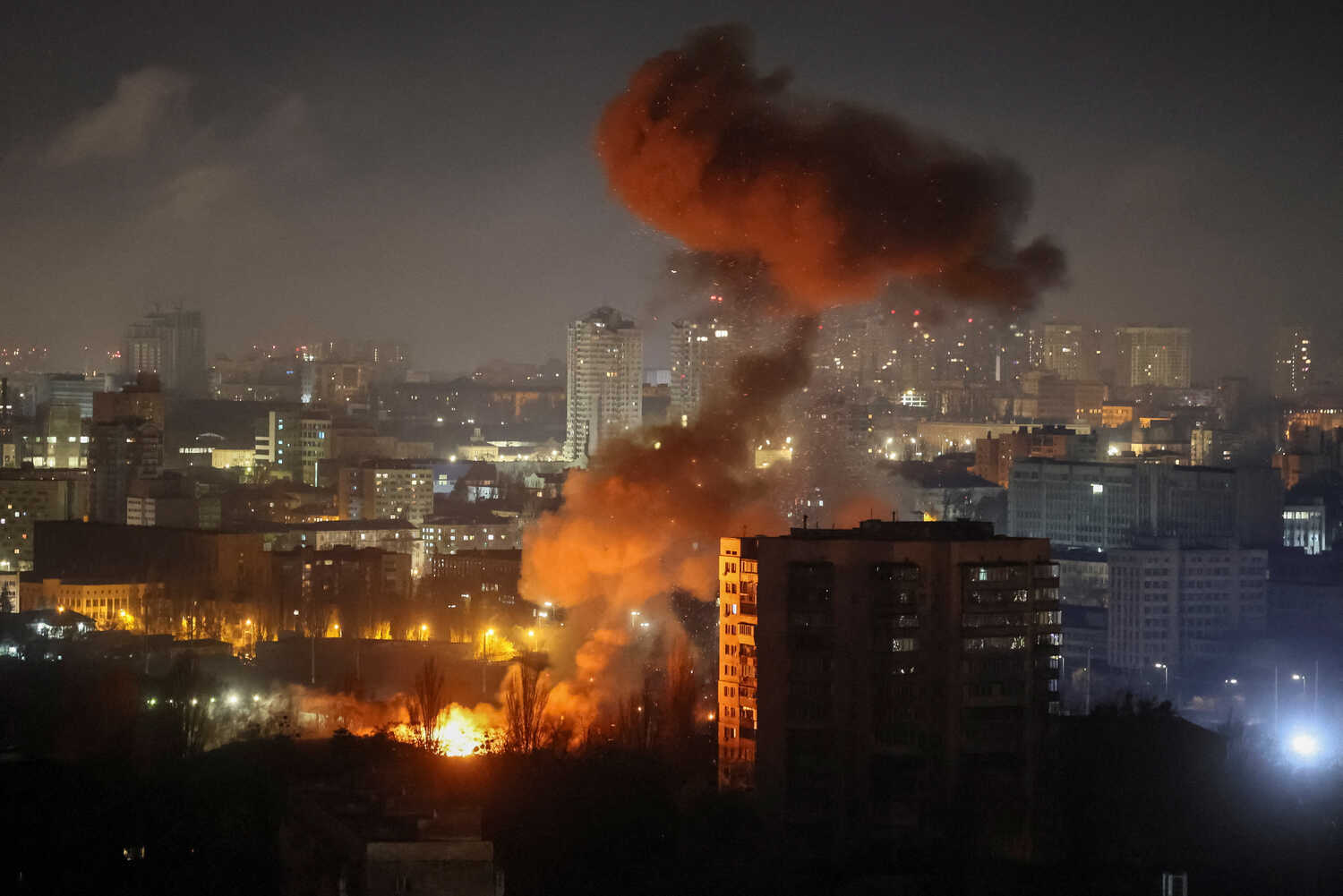 Smoke rising from a fire in a dense city area.